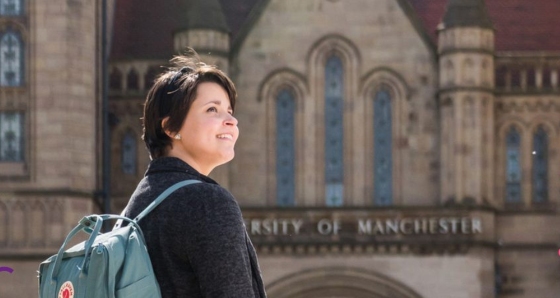 Woman in front of the Queen's Arch on campus.